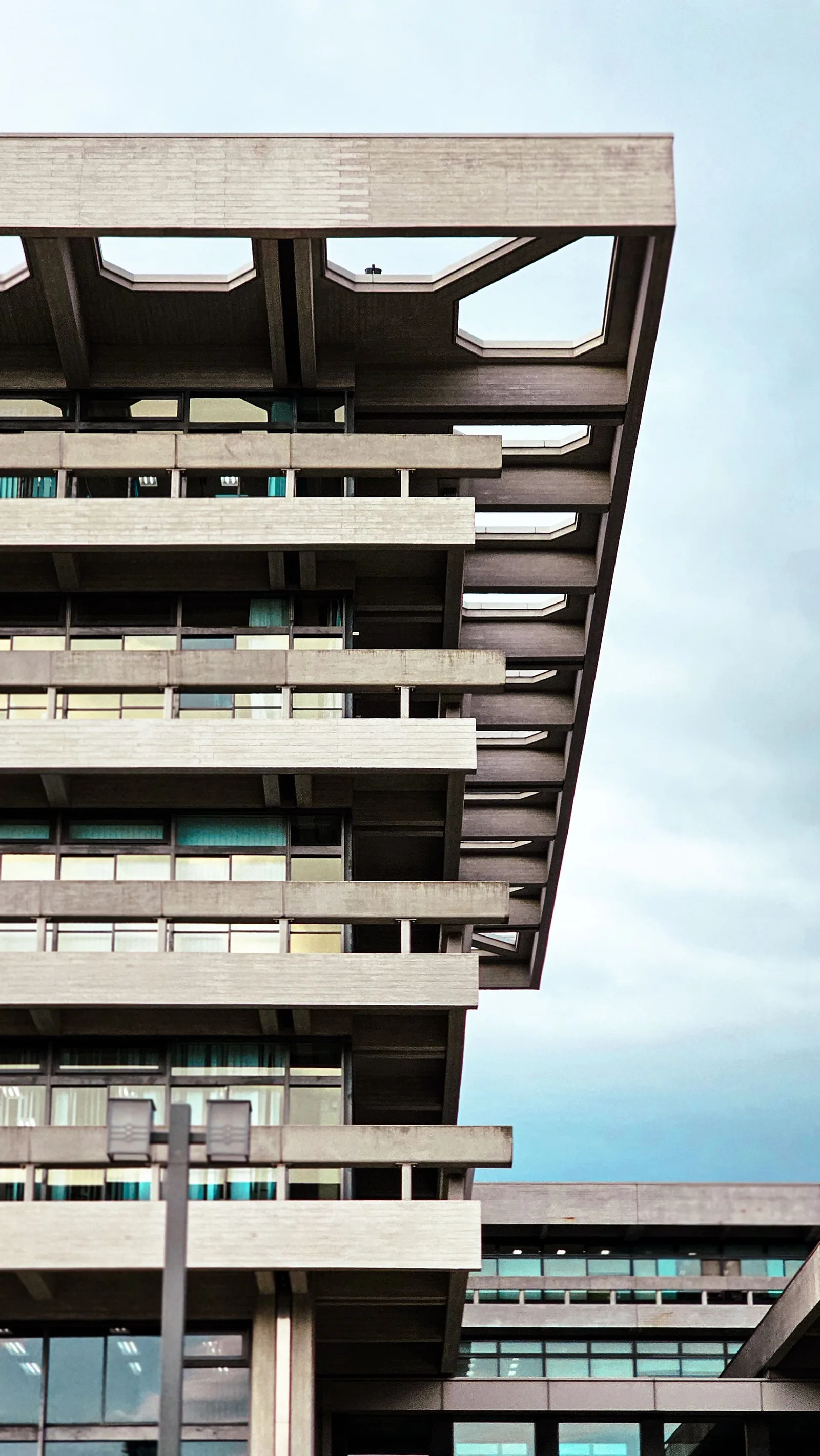 Stacked concrete floors cantilevered over a street
