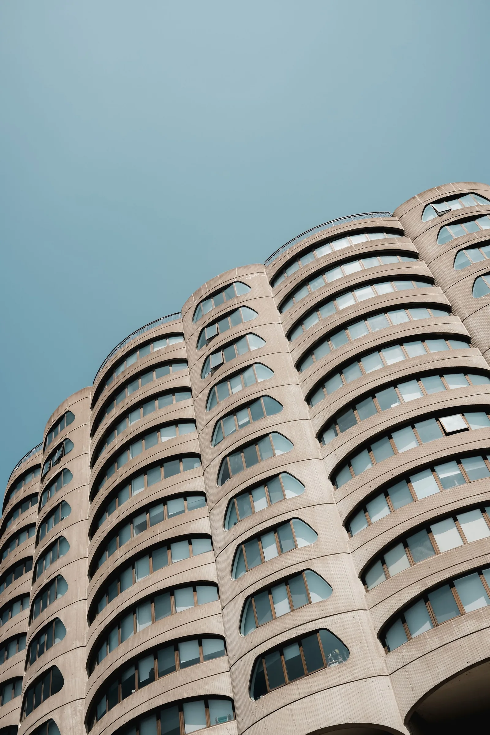 A curved concrete apartment block with rounded window bays