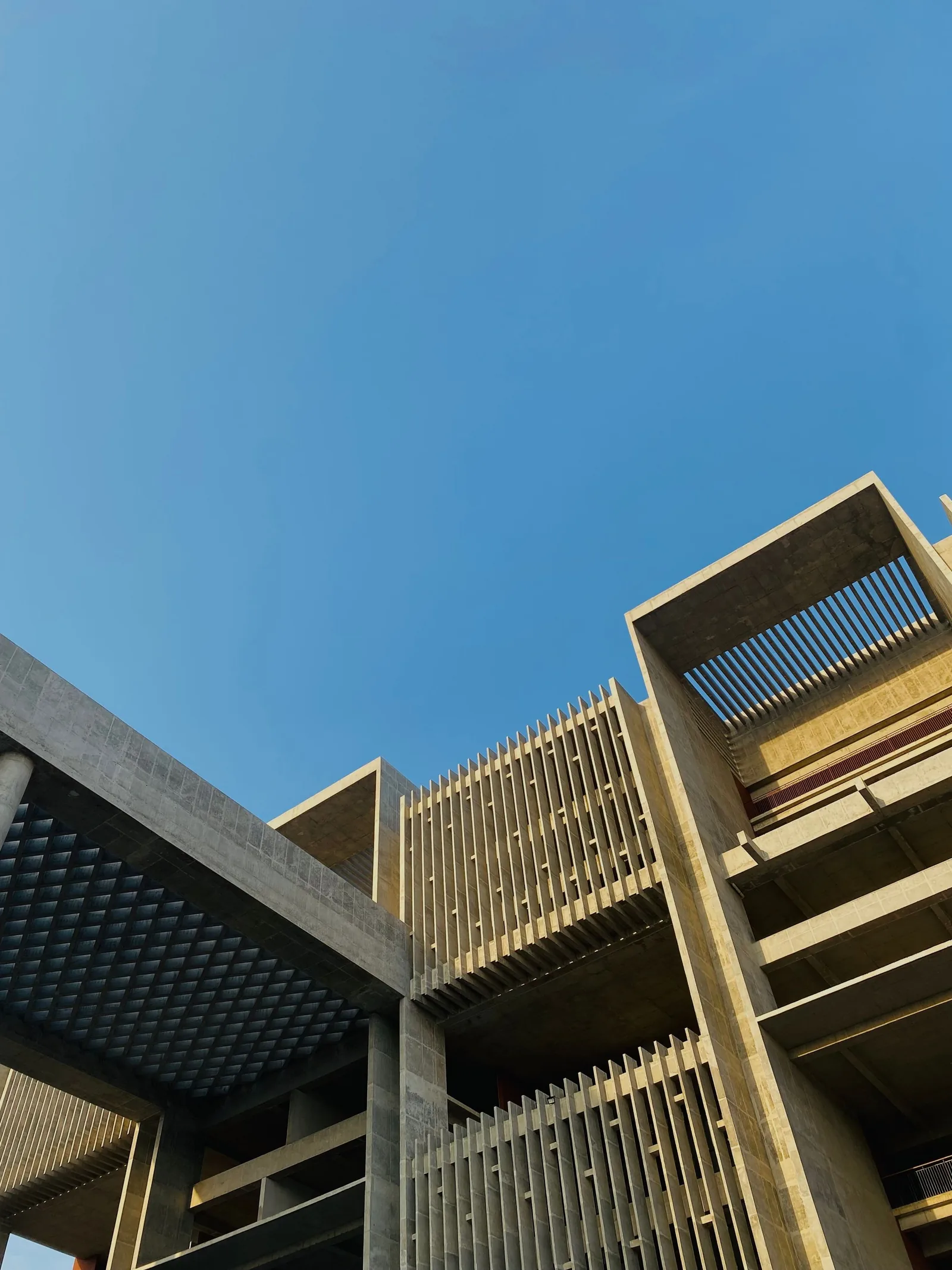 Concrete frames and timber louvres against a blue sky