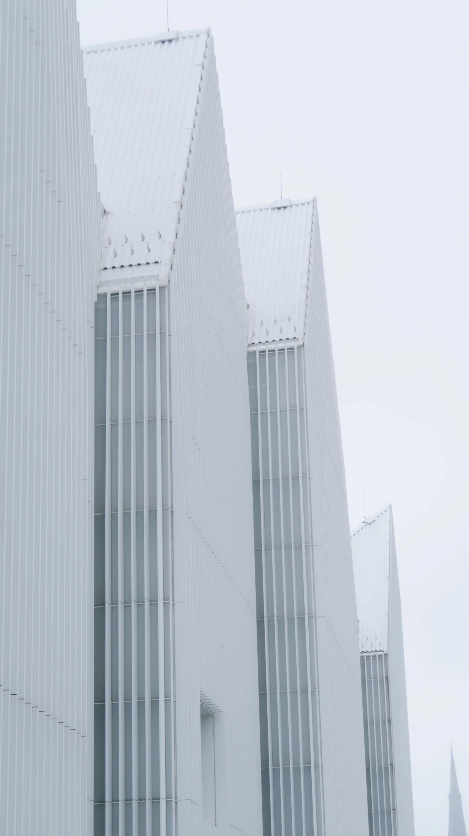Pointed white roofs rising into a pale sky