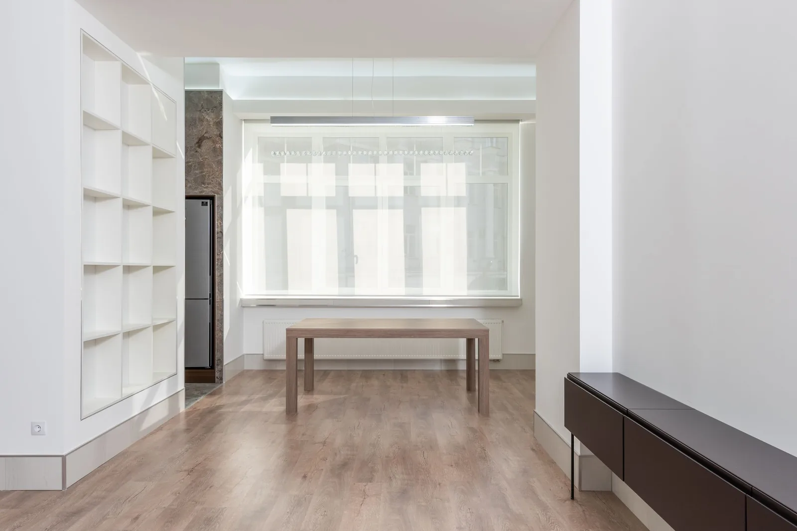 An empty room with timber floor and tall windows