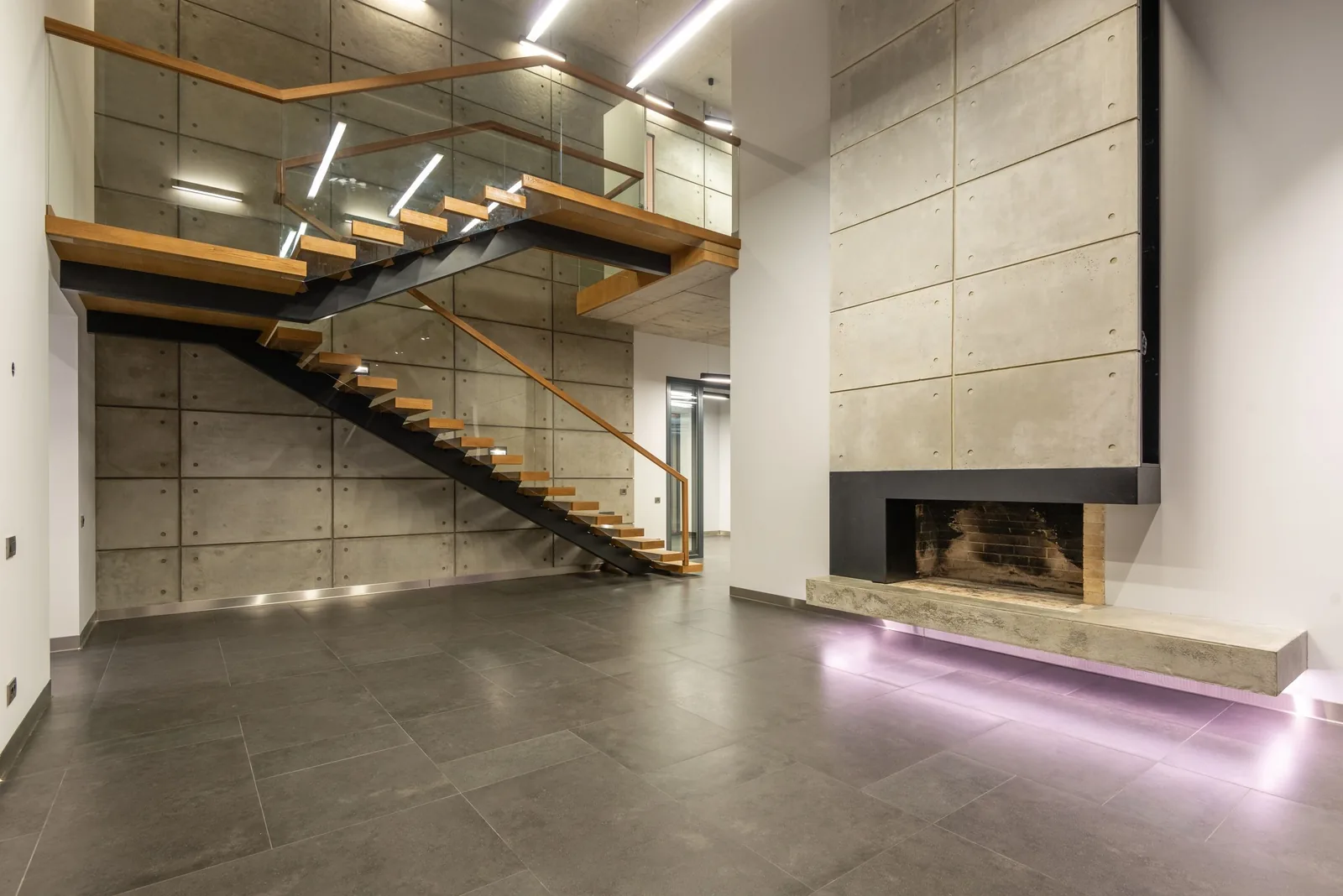 A floating timber stair beside a concrete wall