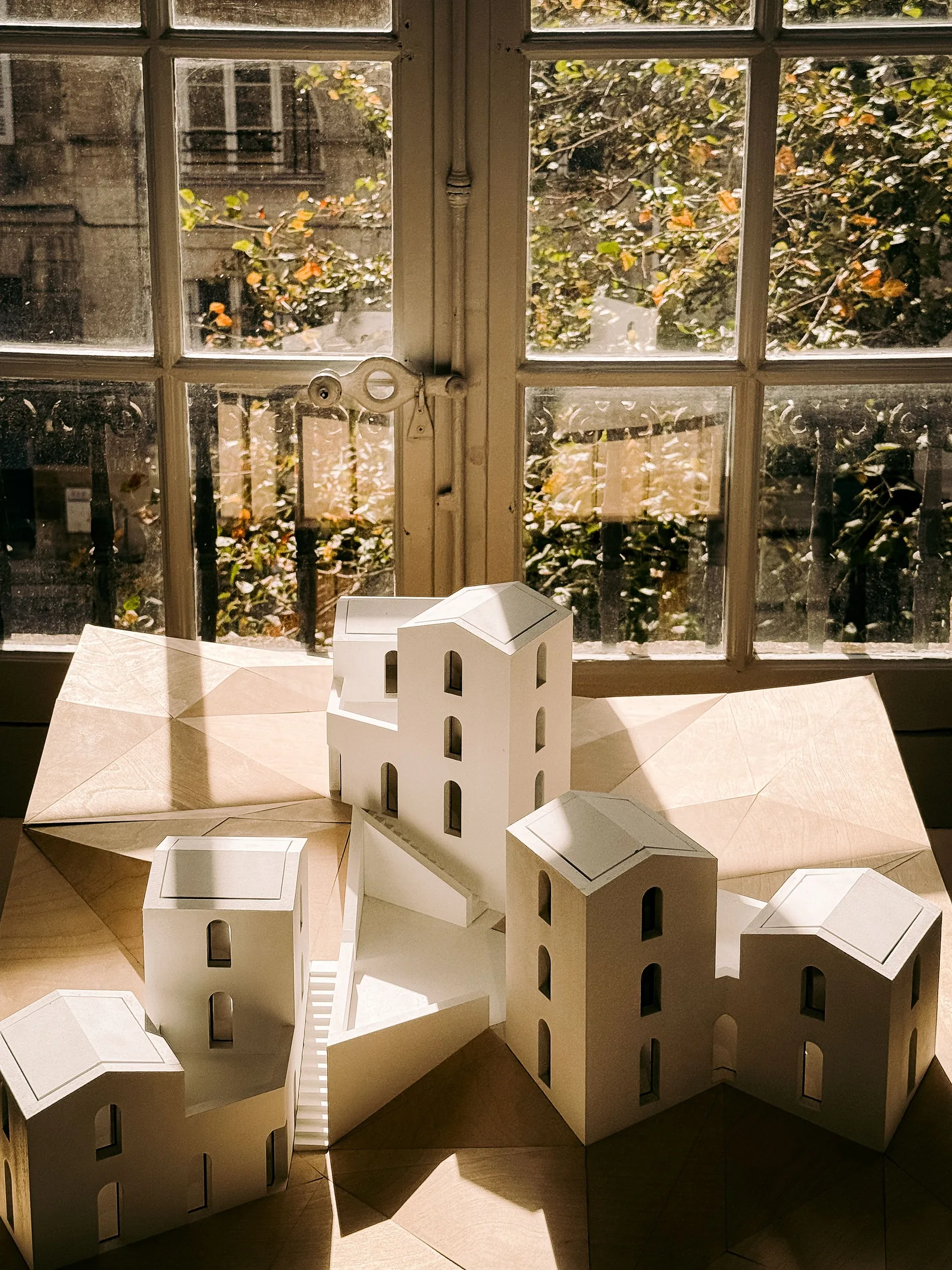 Small paper models of buildings on a sunlit table
