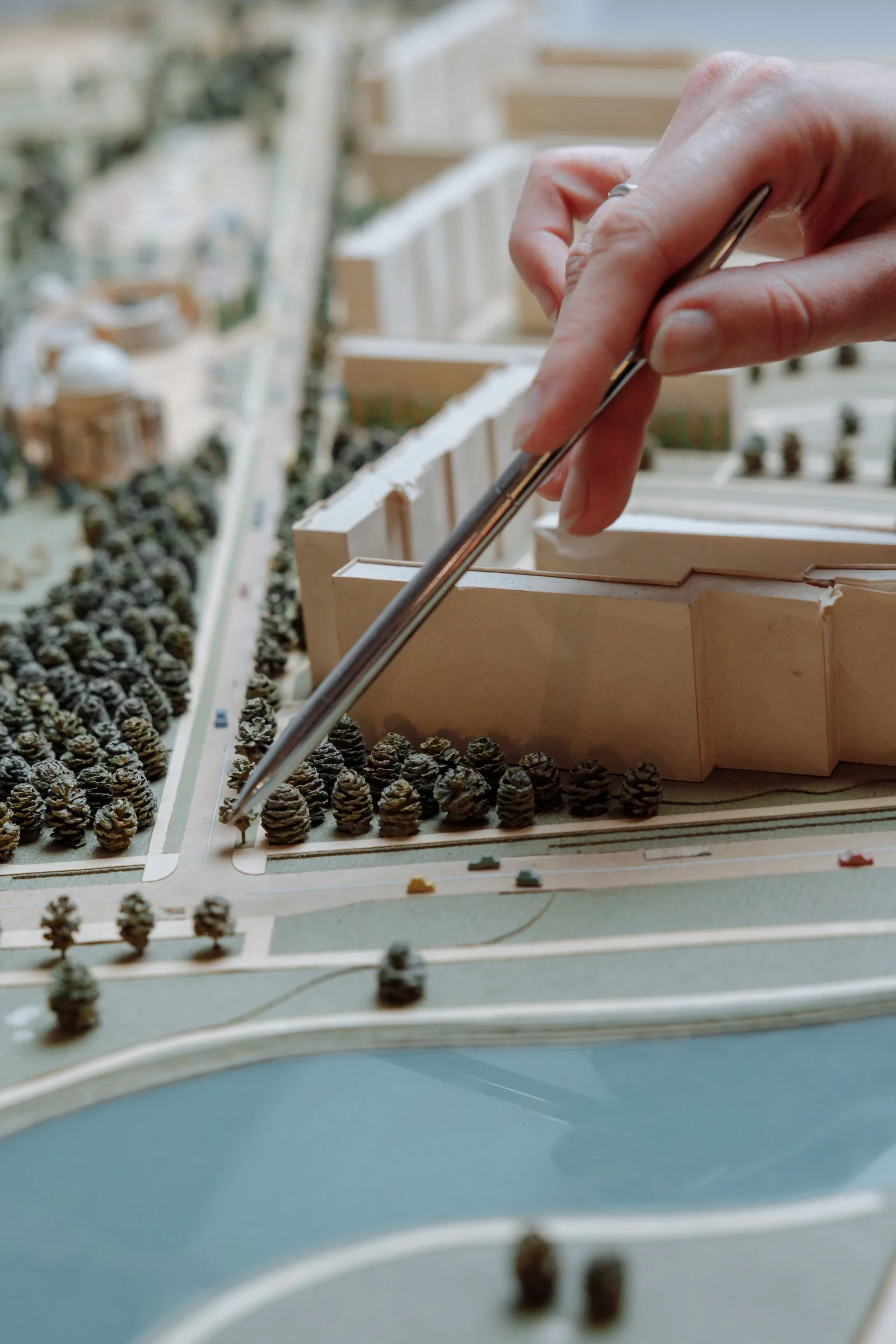 A hand with tweezers placing a tree on a site model